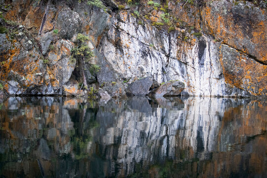 Rocks next to lake with reflection in the water on a summer day near Soldatna, Alaska.