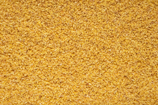 Raw bulgur wheat grains texture background, top view.