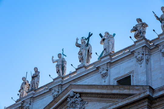 Statues of Christ and the apostles on the facade of St Peter's Basilica against a blue sky, Rome