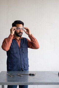 Industrial worker putting on protective safety glasses