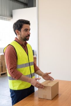 Warehouse worker explaining parcel handling at a workbench