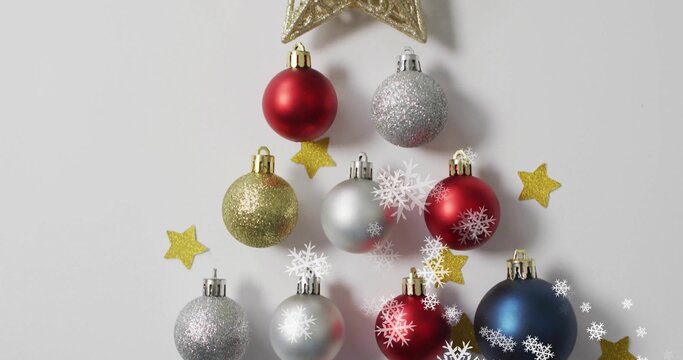 Gold star topping red, silver, gold and blue baubles forming tree shape with snowflakes, copy space