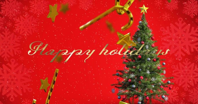 Decorated Christmas tree standing beside gold Happy holidays script on red snowflake backdrop