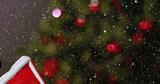 Snow covered red roof resting below evergreen with red ornaments and falling snow during winter