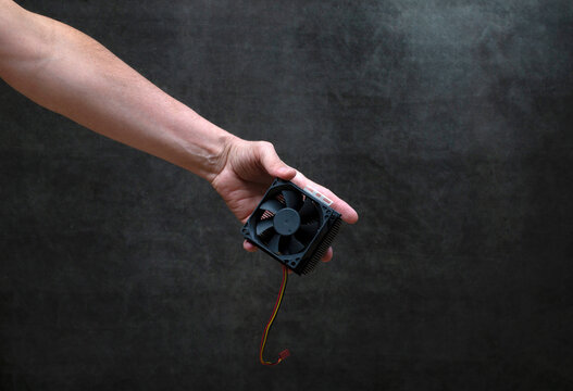 Man's hand passes a computer fan