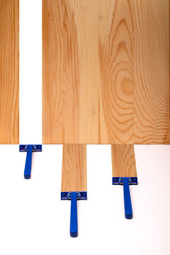 Three razors on a white surface against a background of a wooden board