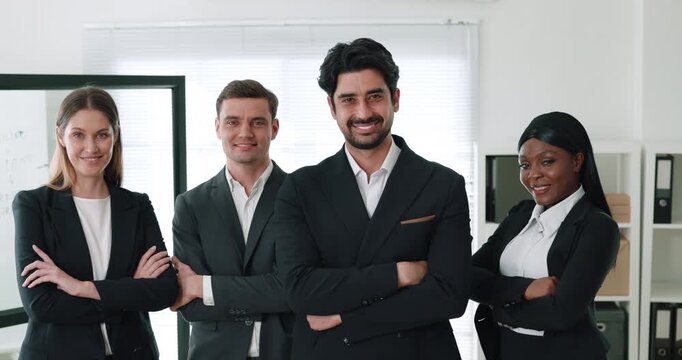 Portrait of cheerful multiethnic businesspeople cross arms in corporate workspace. Business company staff radiates positive vibes on office background