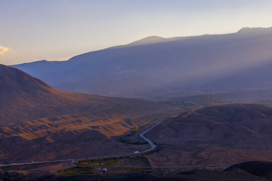 Winding Road Through Mountainous Landscape at Sunset