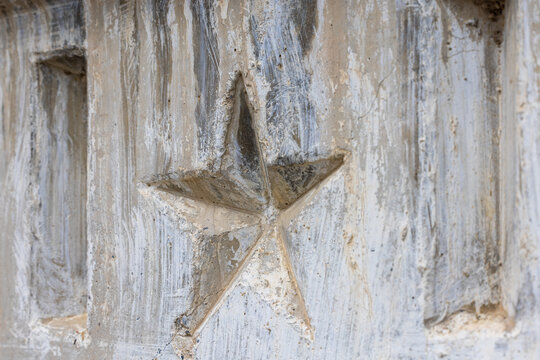 Weathered Concrete Surface with Five-Pointed Star Emblem