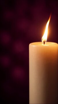 Wax candle burning softly against a deep purple background, casting gentle reflections in a calm space