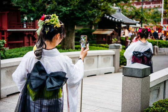 Women wearing traditional japanese kimonos walk along one of the streets in Asakusa district of Tokyo, Japan.