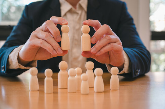 Businessman or HR manager choosing wood doll in concept of Human resources, HR is searching for a right person for a job position. Recruitment with high ai technology skills
