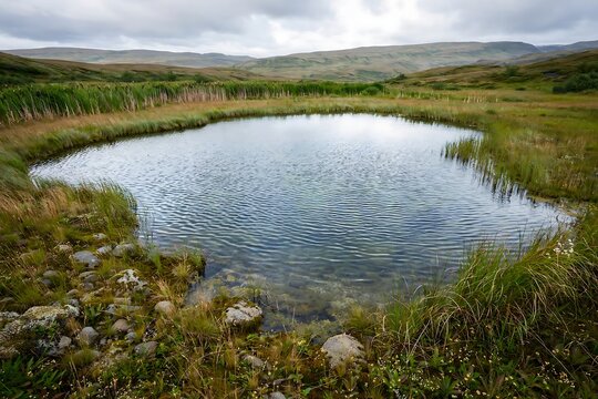 A serene, crystalclear pond nestled in a lush green icelandic landscape with rolling hills under a cloudy sky
