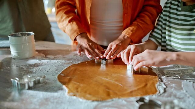 Mom son cutting cookie shapes dough close up. Dad filming baking phone kitchen.