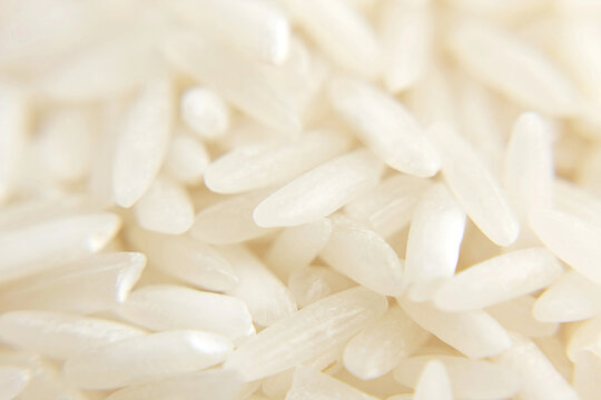 Uncooked jasmine or basmati polished rice grains heap macro structure