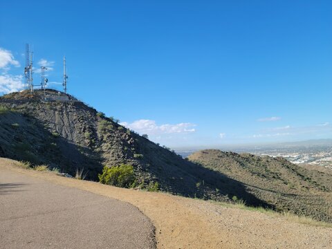North Mountain communication towers and hiking trail in Phoenix, Arizona, overlooking the desert valley landscape under a blue sky