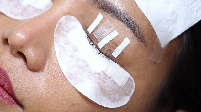 Eyelash extension process in a professional beauty salon, close-up view