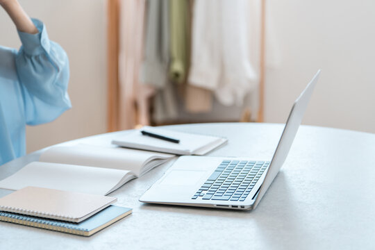 Upper Body of a Woman at a Table with a Laptop and Study Materials at Home