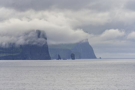 Risin and Kellingin rock needles next to 350m high cliffs, Esturoy, Faroe Islands