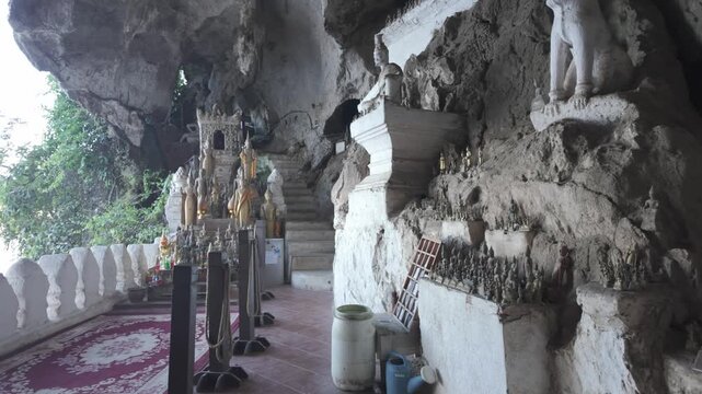Sweeping video shot inside the Pak Ou Caves showing a number of various Buddha Statues in Luang Prabang, Laos