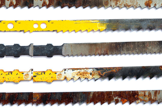 Macro view of carpentry saw blade teeth, rusty textured woodworking instrument, white background