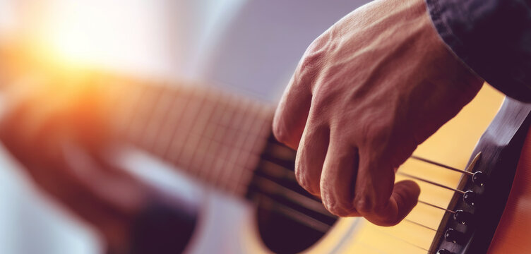 Acoustic guitar player strumming steel strings in warm sunlight, capturing music, creativity, and intimate live performance
