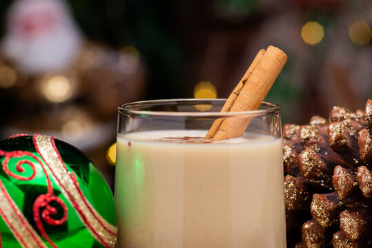 Close-Up of Eggnog in a Glass with Cinnamon and Christmas Decorations