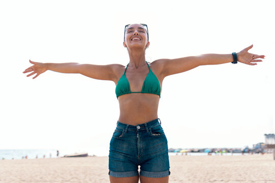 Beautiful young woman enjoying freedom while having fun at the beach