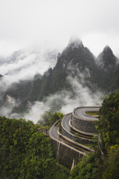 Foggy mountain pass with a winding switchback road