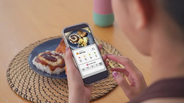 Young adult asian people active using AI phone record data daily meal calorie tracker clean food scan diet app control. Asia Smart living care happy life goal routine plan lunch time home dining table