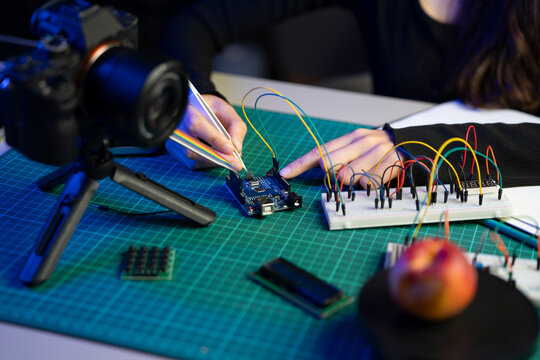 Close-Up of Hands Wiring Arduino Board With Tweezers for AI Camera Circuit Development