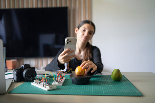 Online teacher demonstrates AI computer vision by weighing fruit with custom microcontroller module.