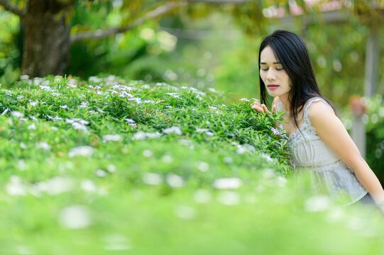 Young Woman Enjoying Nature Amidst Lush Greenery and Flowers