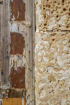 Architectural Texture Transition Between Weathered Wood and Pitted Limestone Wall