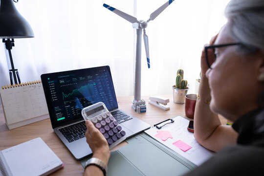 White woman analyzing financial data on laptop with calculator
