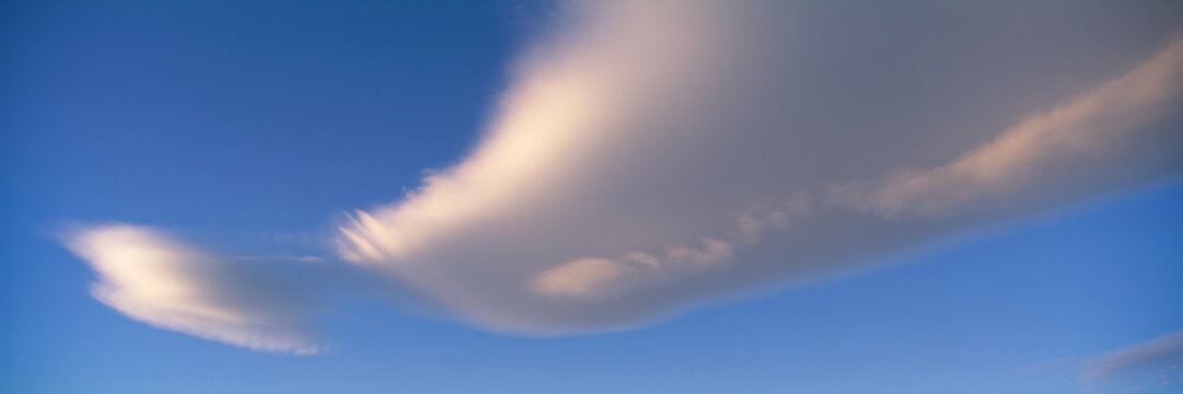 White clouds stretching across a blue sky at sunset