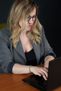Professional Blonde Businesswoman Working with Laptop Computer at Office Desk