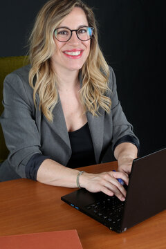 Professional Blonde Businesswoman Working with Laptop Computer at Office Desk