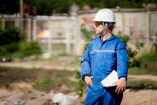 professional engineer, worker, technician use clipboard discuss work, factory plant industry at a gas storage facility. protective uniforms and helmets. industry, engineer, safety