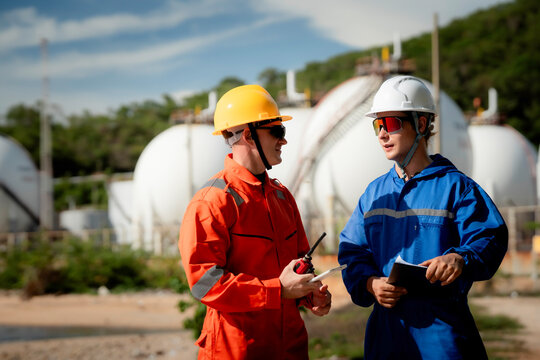 two professional engineer, worker, technician Chemical and gas storage safety inspection concept. Two industrial engineers checking quality and operations at chemical storage tanks. safety, engineer,