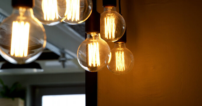 Illuminated Edison bulbs hang against a warm background, creating a cozy and inviting atmosphere