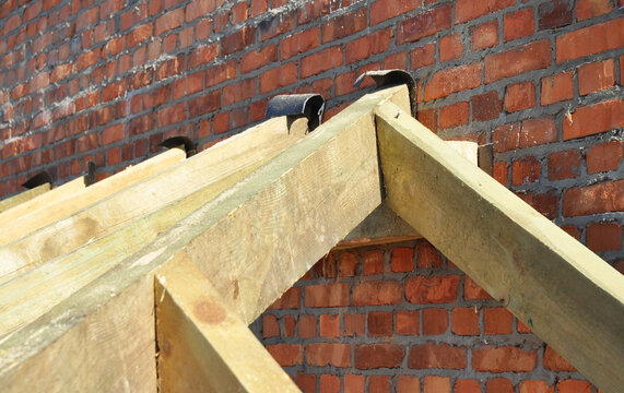 Roof framing waterproofing on brick wall during roofing construction
