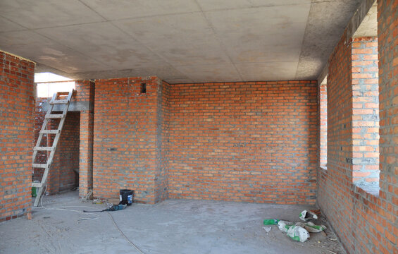 Concrete ceiling in unfinished brick house room interior