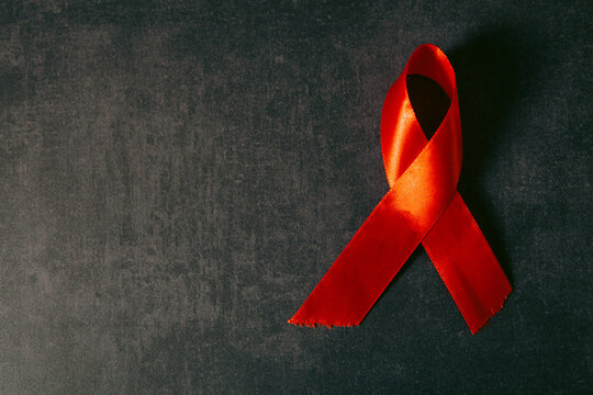 Red ribbon on black background. Symbol of World Aids Day.