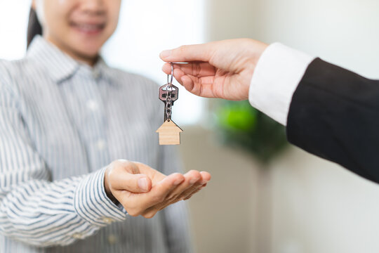 close up view hand of property realtor / landlord giving key house to buyer