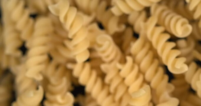 Fusilli pasta falling in slow motion 1000 fps on black background