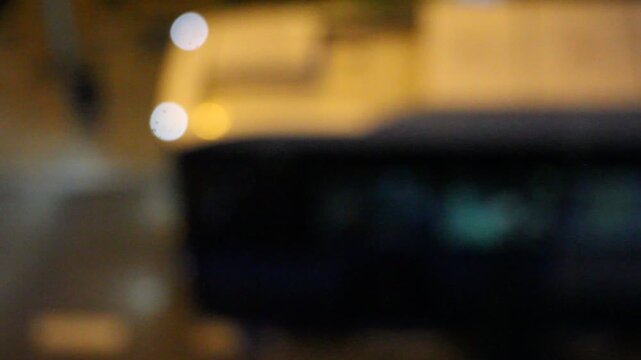 Bus difuminado autob&uacute;s nocturno con desenfoque borroso en parada por la noche luz intermitente veh&iacute;culo distorsionado en oscuridad