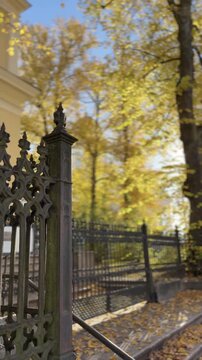 Ornate Iron Fence and Golden Autumn Trees Vertical Video
