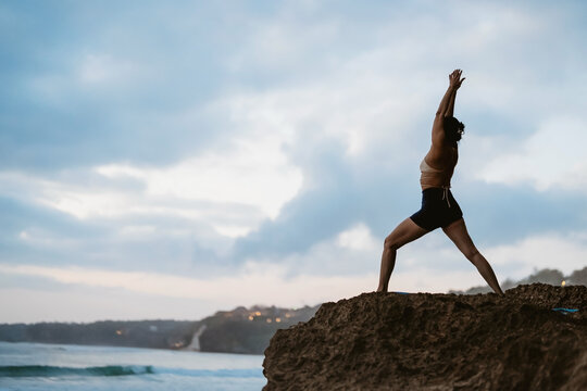 Serene asian woman practicing yoga and mindfulness on a peaceful tropical beach