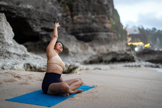 Serene asian woman practicing yoga and mindfulness on a peaceful tropical beach